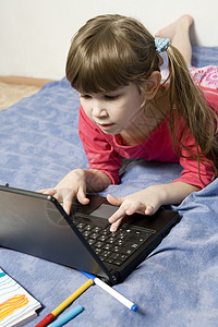 7岁的可爱小女孩玩电脑游戏的7岁女孩电脑孩子家庭作业动机享受乐趣学习者技术爱好图片