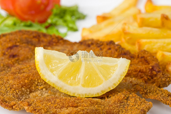 盘子上的雪梨肉排的细细细节薯条棕色食物猪肉面包屑午餐叶子柠檬图片