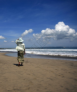 海滩上的女人蓝色孤独海岸线海岸旅行成人石头天空裙子女士图片