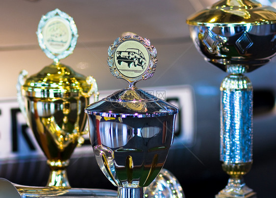 赛车比赛的奖杯或Autamo队背景奖牌勋章游戏冠军金属金子汽车杯子优胜者竞争者运动图片