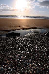 卵石海滩地平线岩石橙子海岸线戏剧性天空巨石蓝色海景石头图片
