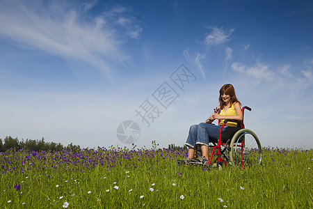 轮轮椅残疾妇女蓝色椅子成人轮椅草地享受情感保健残障活动图片