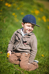 带丹德利翁的男孩草地场地童年帽子孩子男生晴天季节公园绿色图片
