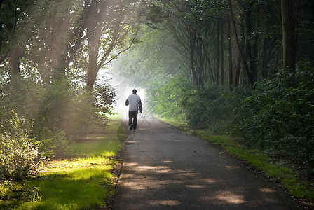 中年男子清晨慢跑黄色跑步叶子绿色公园阳光光束风景森林树木图片