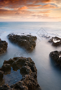 珊瑚礁海岸线的日落晴天沿海蓝色海岸岩石假期旅游日出珊瑚石头图片