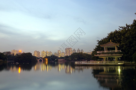 夜间在湖边公园池塘发光夜景亭子建筑物树木反射图片