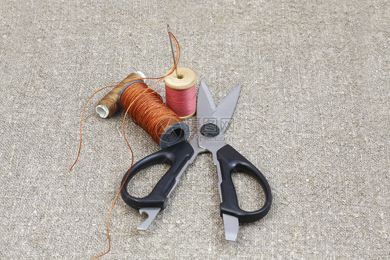 剪刀 针和线在垫子的画布上黑色材料刀具计划缝纫线圈金属工具灰色绳索图片