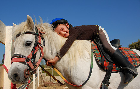 女童和沙特兰小马友谊伴侣马背眼睛头盔骑术朋友孩子们动物微笑图片
