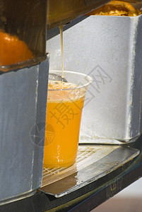 自动榨汁机新鲜橙汁钻入杯中背景