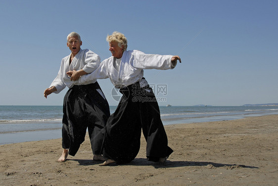 在海滩上训练合木道成人专注武士说明格斗海洋男人运动瞳孔操作图片