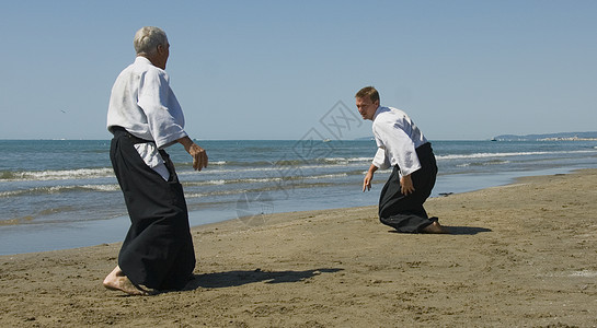 在海滩上训练合木道成人武士格斗专注男人海洋运动操作瞳孔说明图片