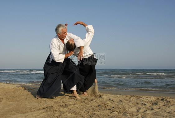 在海滩上训练合木道武士成人瞳孔格斗运动海洋男人专注操作说明图片