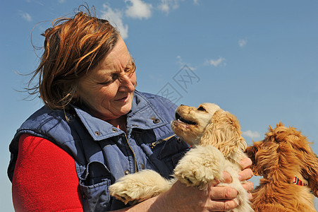 高级女子和狗女士宠物微笑蓝色小狗犬类幸福天空金子棕色图片