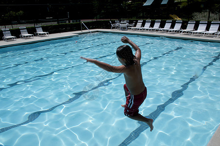 小男孩跳进游泳池童年假期孩子孩子们闲暇水池游泳者乐趣游泳生活图片