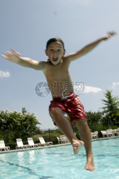 小男孩跳进游泳池孩子游泳者游泳童年闲暇假期孩子们水池乐趣生活图片