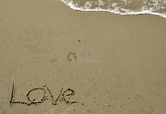 爱在沙沙中与海浪一起写作岩石海洋泡沫贝壳电子海滩图片