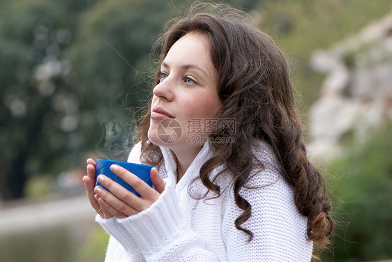 这名年轻女子的肖像 一杯户外热饮的杯子夹克楷模肤色毛衣女性蓝色头发皮肤咖啡手指图片