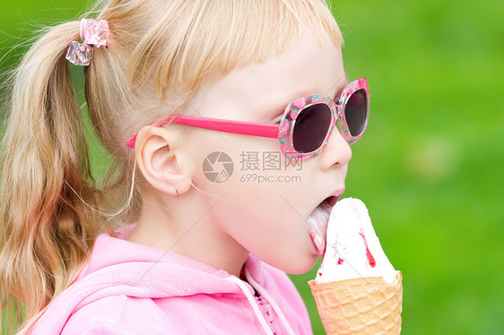 吃冰淇淋的小女孩 吃冰淇淋的小女孩喜悦垃圾乐趣食物嘴唇孩子锥体婴儿金发童年图片