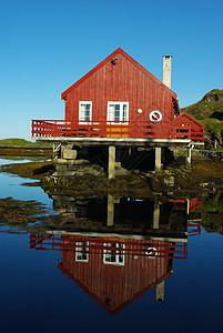 海洋上的房子红色石头木头蓝色天空小屋游客棕色海岸线日落图片
