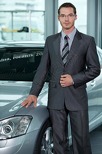 坐在汽车展厅的汽车销售员肖像头灯眼镜奢华优雅销售代理商展示人士商务未来派图片