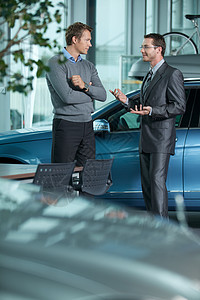 汽车销售员向客户解释汽车特写顾客奢华两个人沟通外表展览会技术职业交通衣冠图片