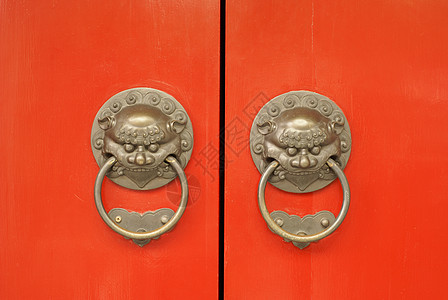 古代东方红色庙门 配有装饰性狮子头戴拳击手图片