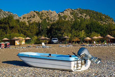 背景在海滩和黄阳伞上的机动艇图片