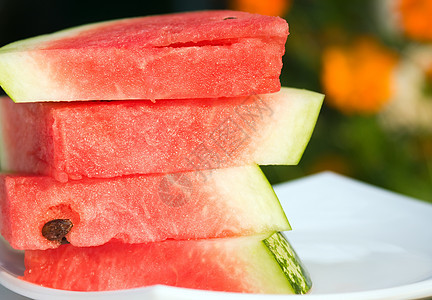 新鲜的西瓜片盘子宏观团体水果小吃绿色西瓜红色种子倾斜图片