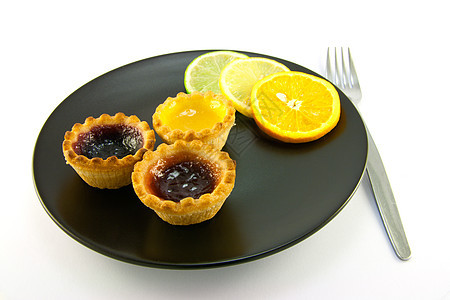 带有Citrus切片和叉子的 Jam Tarts食物盘子派对脆皮馅饼食谱蛋糕柠檬咖啡店甜点图片