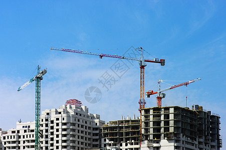 建筑高塔起重机在天空背景上蓝色店铺柱子工程灰色框架绞刑架三角帆多云白色图片