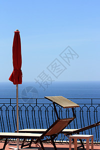 俯视地中海的红雨伞和防晒床图片