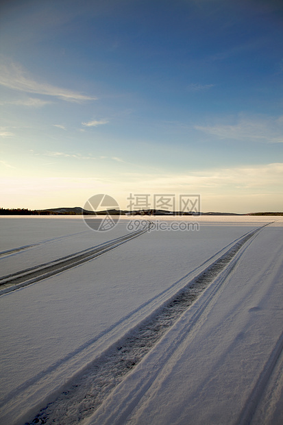 积雪中的轨迹摩托天空季节雪地蓝色太阳小路场景雪道图片