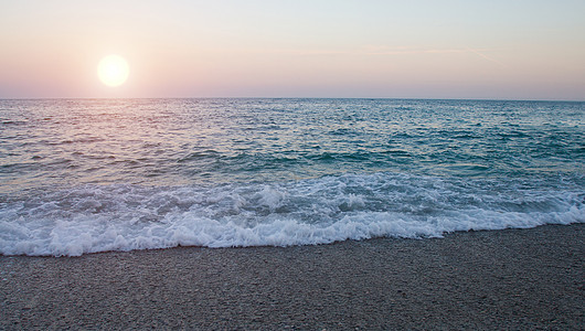海中的日落天际太阳地平线风景波浪反射天空紫色黑色海岸线图片