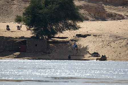 埃及阿斯旺附近尼罗河蓝色阳光石头帆船河岸沙漠岩石旅行反射旅游图片