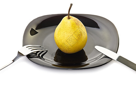 用叉子刀和叉子在黑色盘子上的黄梨图片