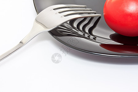 红西红番茄在黑色盘子上 有叉叉图片