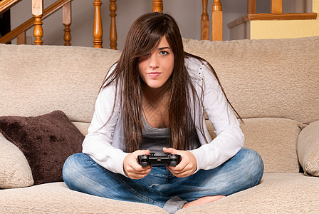 在家沙发上玩视频游戏的年轻女性专注青年享受女孩黑发挑战房间控制器安慰喜悦幸福图片