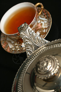 银茶壶 把茶倒进中国杯图片