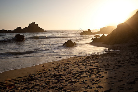 菲佛海滩海洋戏剧性风景岩石波浪日落悬崖海滩冲浪海岸线图片