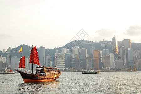 有红帆船的香港港港反射摩天大楼中心游客建筑旗帜血管爬坡桅杆顶峰图片