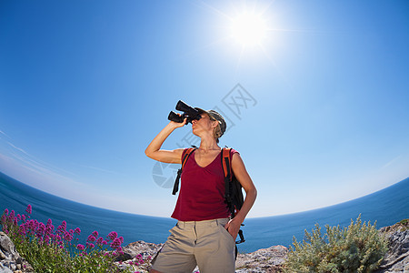 妇女徒步旅行鱼眼冒险女子观鸟者望远镜背包服装活动阳光中年图片