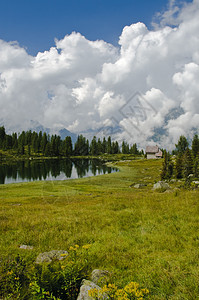 意大利阿尔卑斯山的湖景池塘森林蓝色松树树木建筑天空岩石木头教会图片