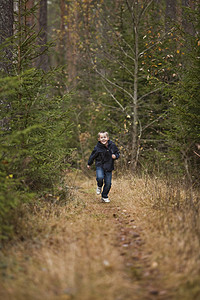 小男孩跑步寂寞速度运动阳光孩子体力泥路休闲活动绿色图片