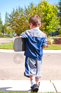 小男孩准备滑板了背景图片