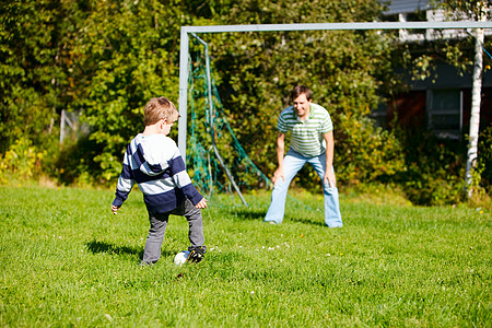 家庭踢足球幸福男生友谊孩子成人绿色父母游戏爸爸时间图片