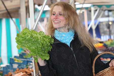 带着沙拉的在市场中微笑的女人图片