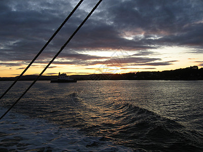 日落在borad 船上水手游艇红色帆船旅行太阳波浪水手们桅杆血管图片
