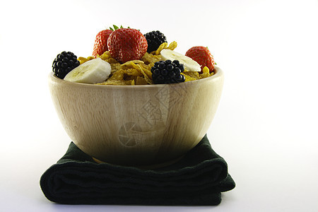 玉米片和水果在与Napkin的碗中蜂蜜餐巾木头谷物营养浆果玉米早餐厨房薄片图片