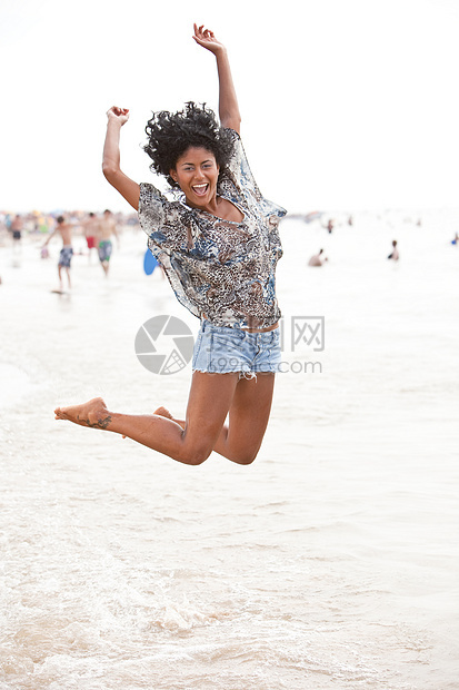 在沙滩上欢乐快乐全身女性化多样性海洋海滩牛仔裤幸福女性图片