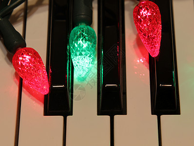 三个圣诞灯在钢琴上图片
